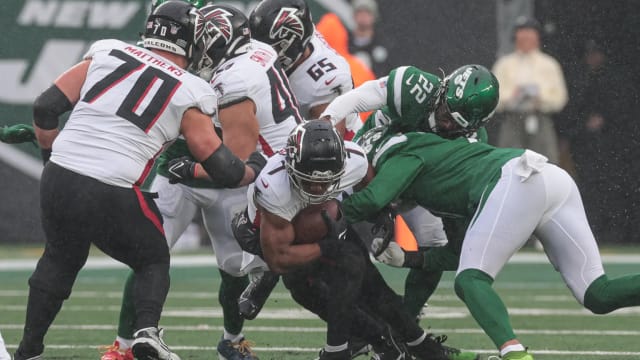 Dec 3, 2023; East Rutherford, New Jersey, USA; Atlanta Falcons running back Bijan Robinson (7) is tackled by New York Jets linebacker Jermaine Johnson (11) and safety Tony Adams (22) during the first quarter at MetLife Stadium.